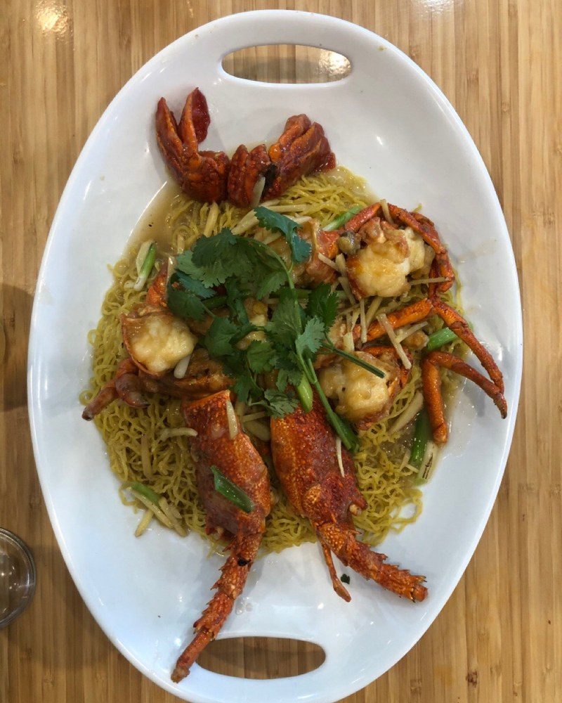 Lobster stir-fried with ginger and spring onion over egg noodles, topped with coriander