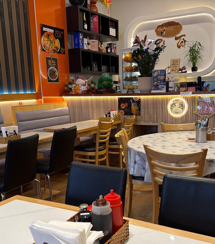 Grey banquettes and a round family table looking toward the Windsor Avenue counter