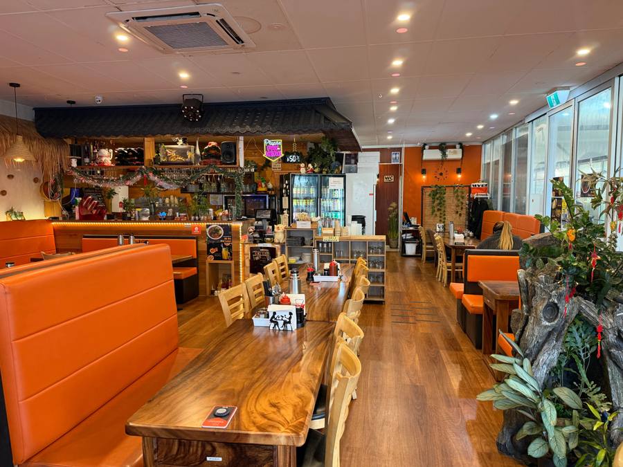 The Athol Road dining room set for service, looking down the length of the timber tables to the counter
