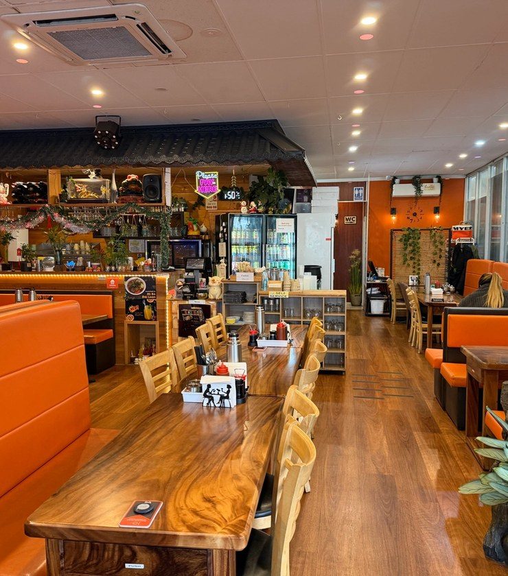 Looking down the length of the room, past the booths to the counter and the street windows